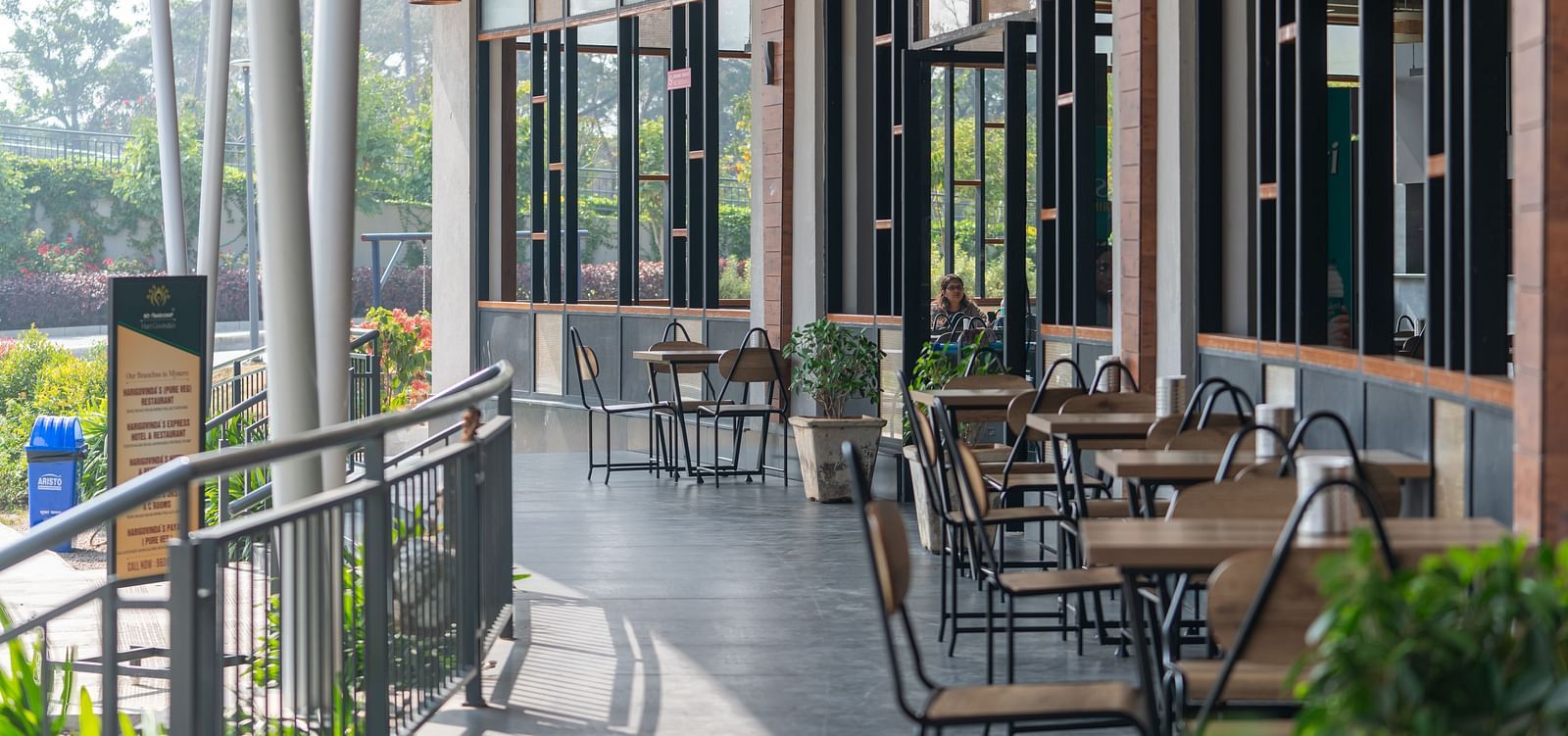 Outdoor dining area at Hari Govinda's, where tables and chairs are set beside the wall