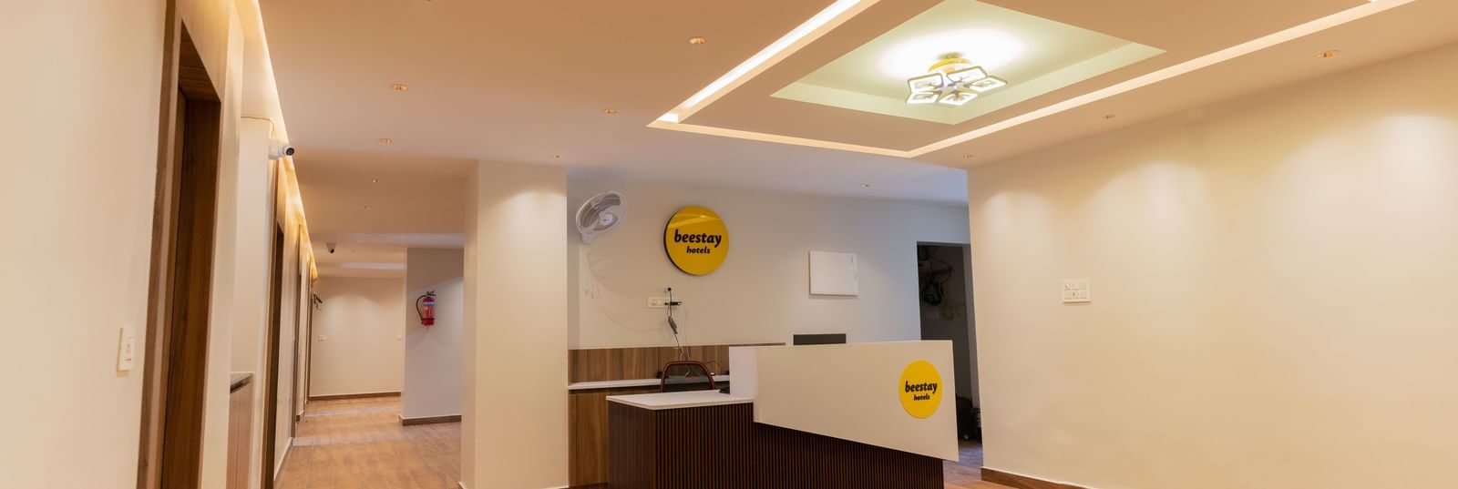 Spacious front desk area with wooden flooring and bright interiors at Beestay Hotels, Rajahmundry.
