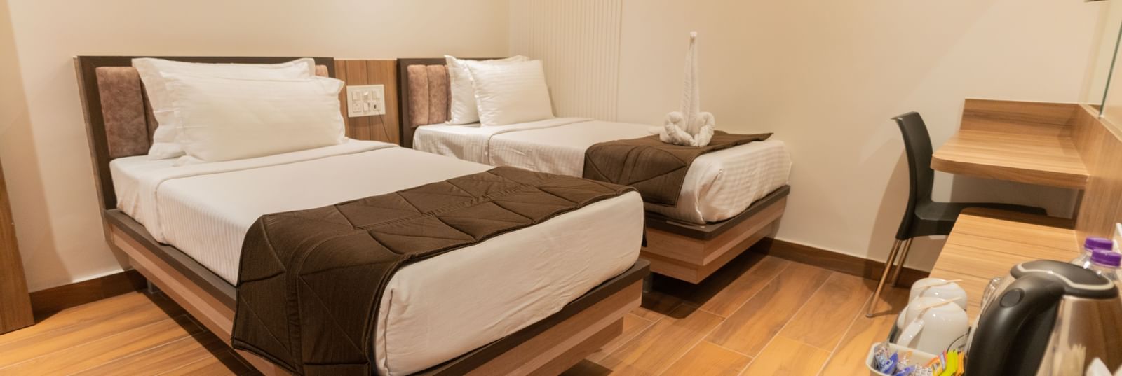 Comfortable twin beds with modern flooring and soft lighting at Beestay Hotels, Rajahmundry.