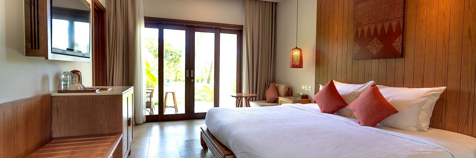 Side view of a room with bed, televisison and large window with wooden ceiling
