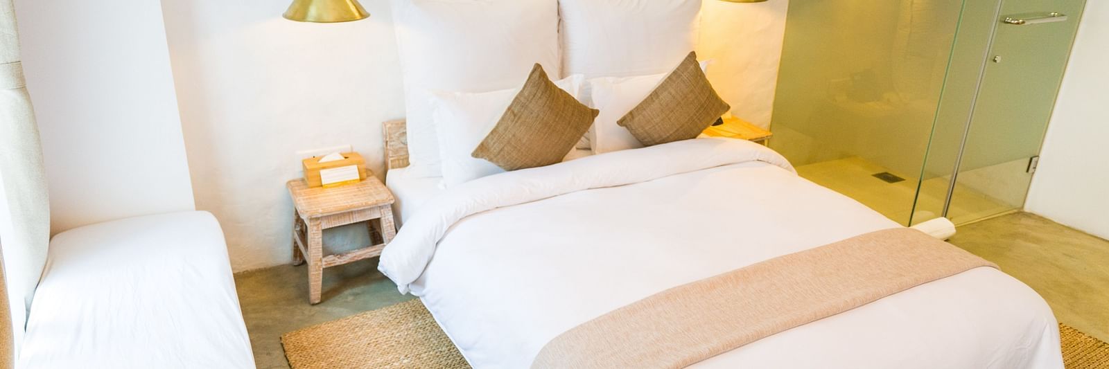 Deluxe loft room with a double bed, and a single bed side tables, and lamps hanging from the ceiling - The Nanee
