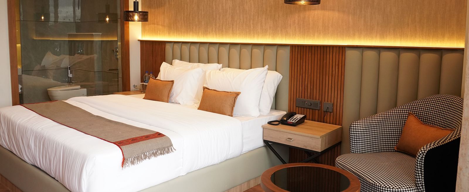 Compact double bedroom with soft lighting, modern furniture, and seating space – ARNISA Boutique Hotel