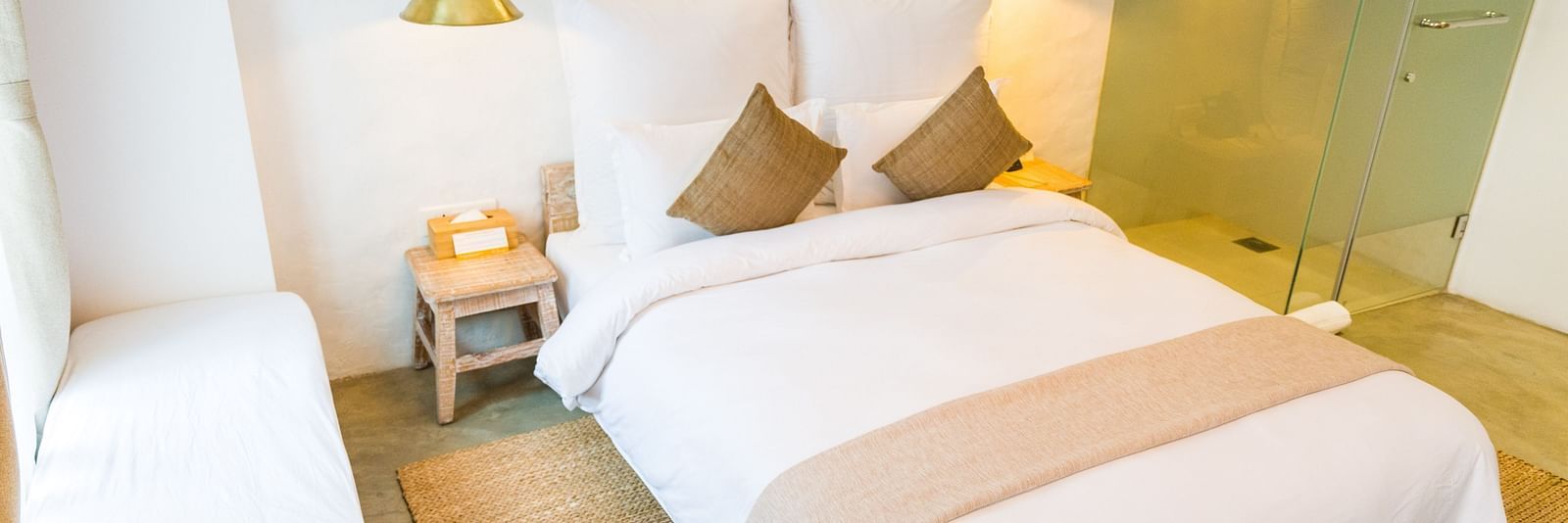Deluxe loft room with a double bed, and a single bed side tables, and lamps hanging from the ceiling - The Nanee