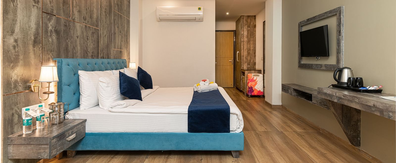 A premium room image with a bed, bed side tables, a flat screen TV, and room amenities like tea and coffee maker - DLS Ganga Bliss, Haridwar