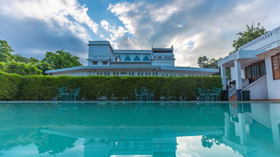 Outdoor swimming pool at Saraca Hotel, Lucknow with the hotel building in the backdrop on a cloudy day