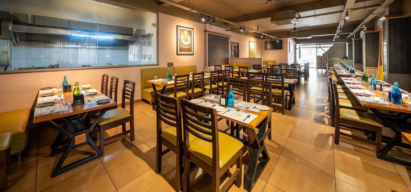 Image of a dining area with tables and chairs arranged around it at Hari Govindas, Siddappa Square.