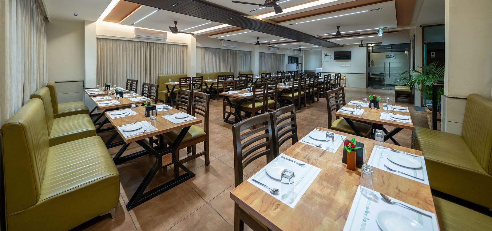Dining area with close-up view of the neatly set table and chairs kept on both sides of the table at Hari Govinda's