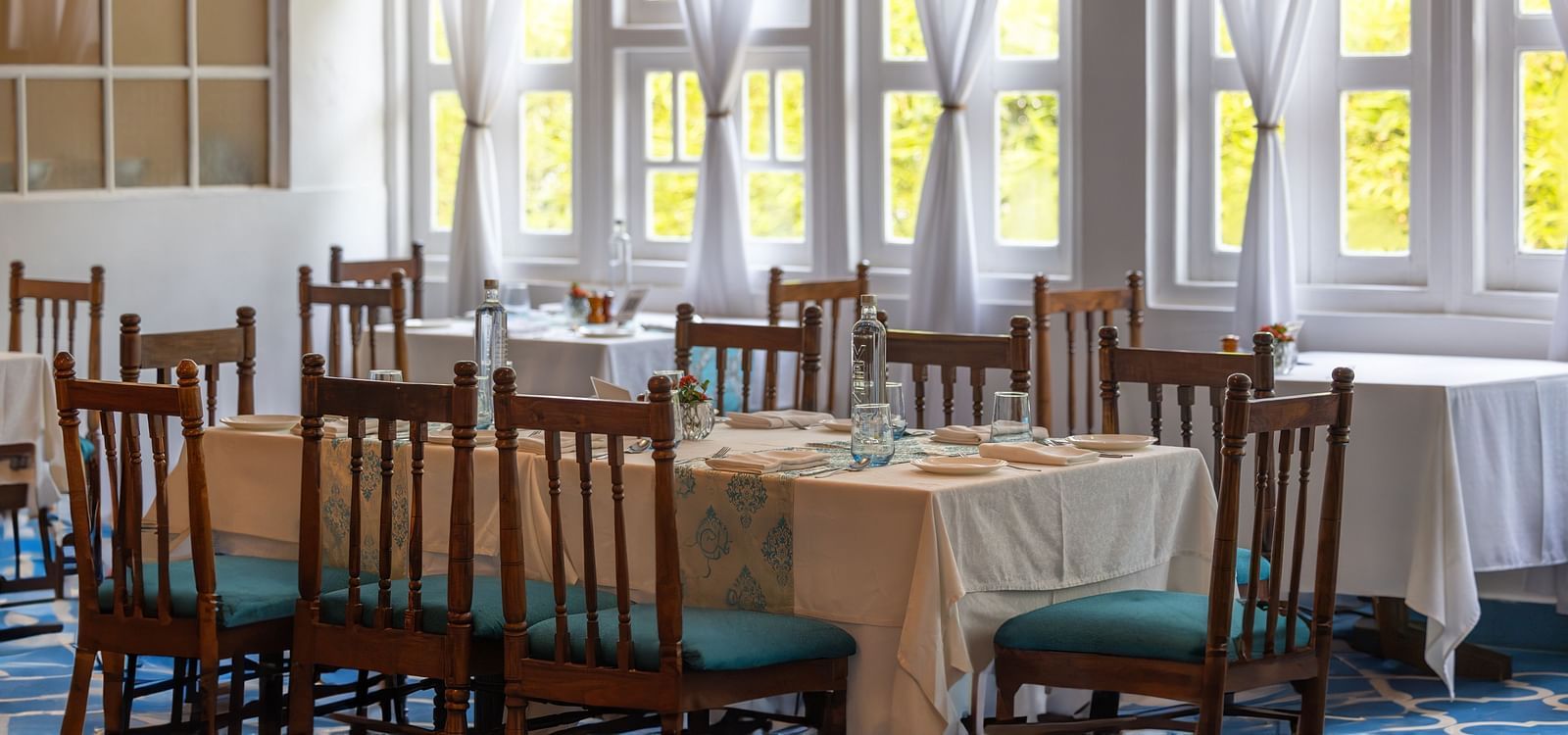 Interiors of Azrak Restaurant at Saraca Hotel, Lucknow with dining arrangement placed in front of large windows