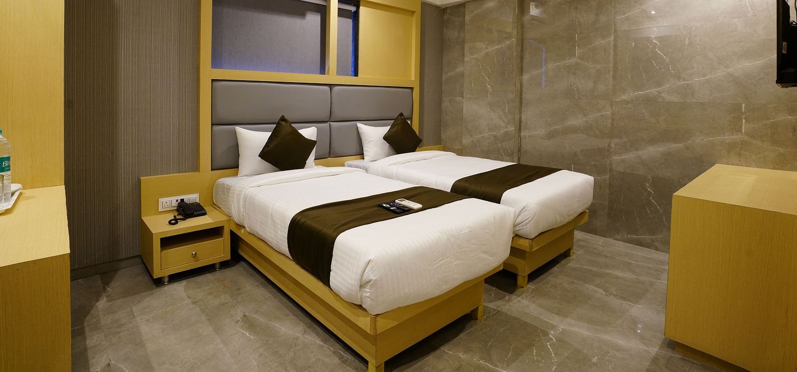Hotel room with two single beds, wooden frames, and air conditioning - Shyanu Lords Eco Inn Airoli