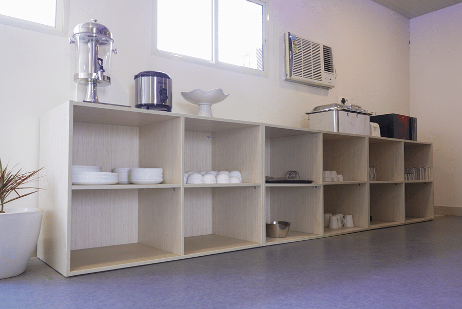Breakfast counter with shelves of crockery and a tea urn at Lime Tree Hotel, Pulkit, Gurgaon