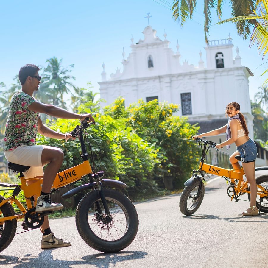 Guests riding electric bikes near the heritage site in Goa.