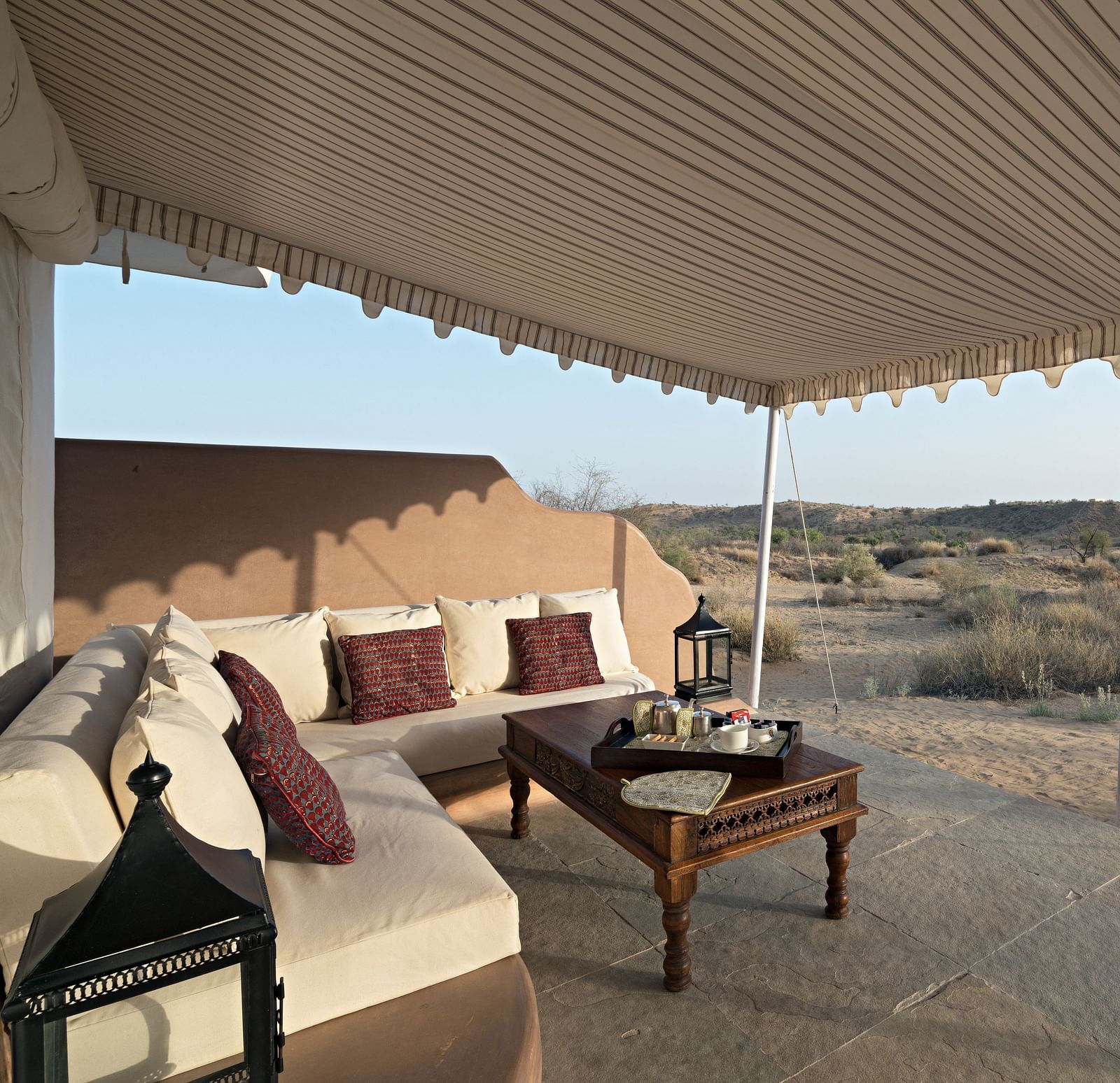 A close-up view of a luxury tent with sofa and table illustrating the comfort and solitude offered in the desert surroundings - MANVAR Resort & Desert Camp