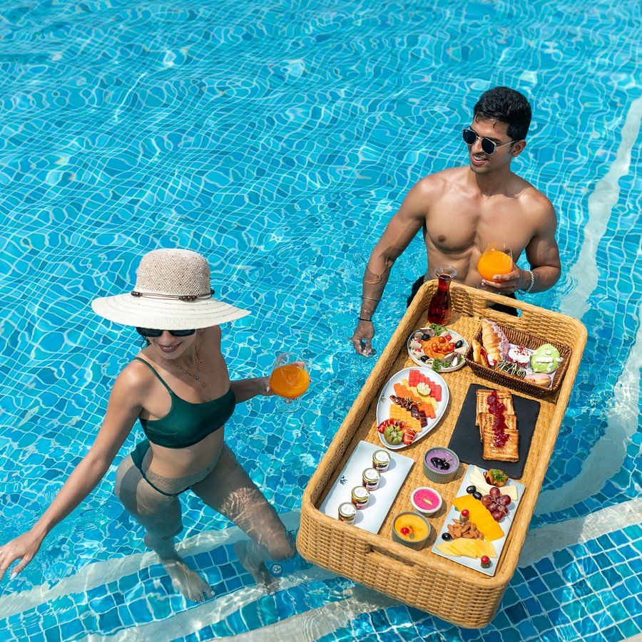 A couple enjoying a poolside breakfast in the water at Heritage Village Resorts & Spa.