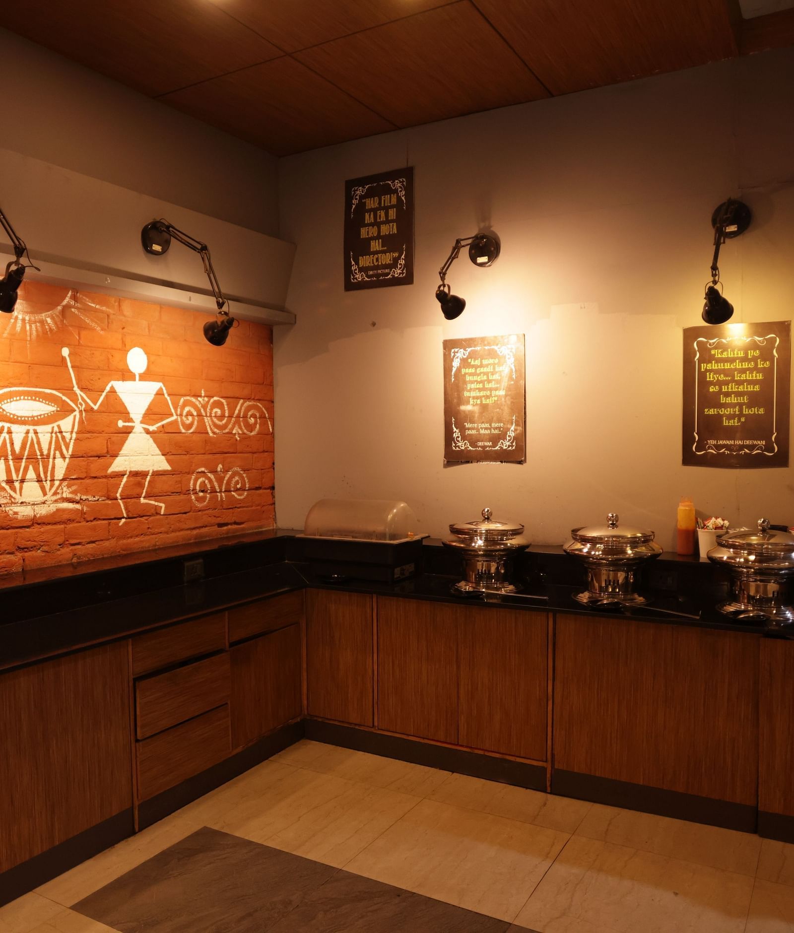 A dimly lit hotel buffet area with a marble counter and decorative items at Max Hotel Prayagraj.