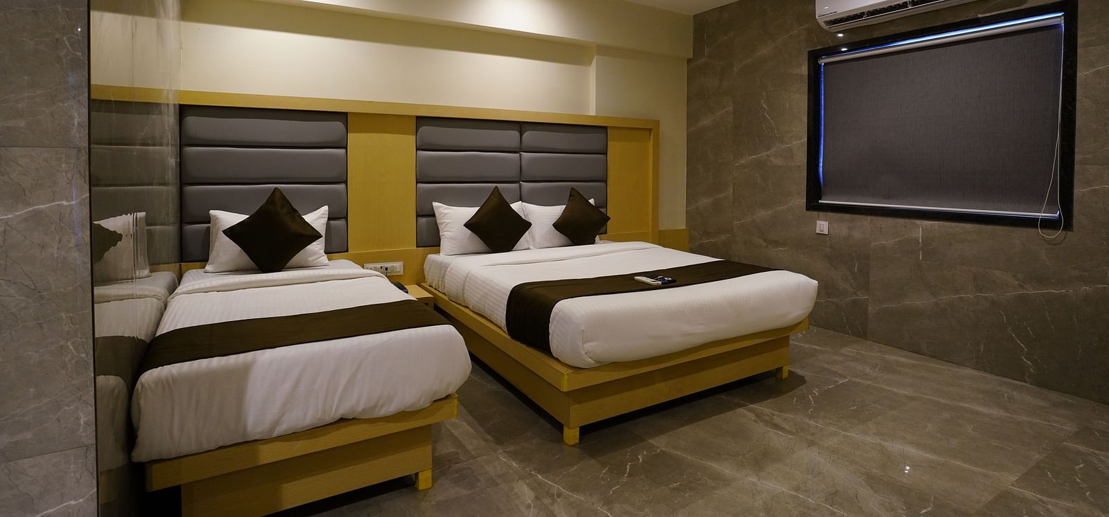 Hotel room with two single beds, bedside tables, and a window - Shyanu Lords Eco Inn Airoli