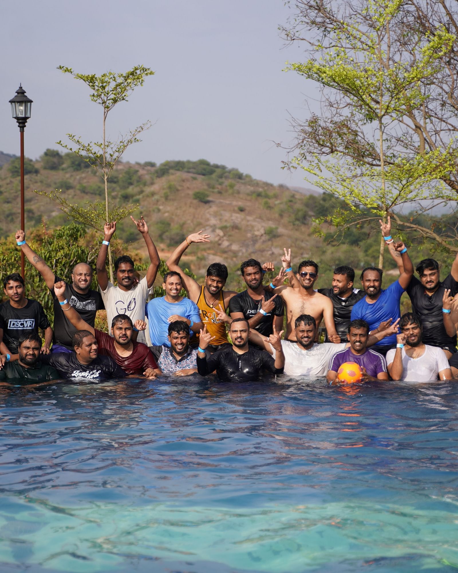 Ravishing Retreat Ramanagara - A group of guests posing for a group photo in the swimming pool