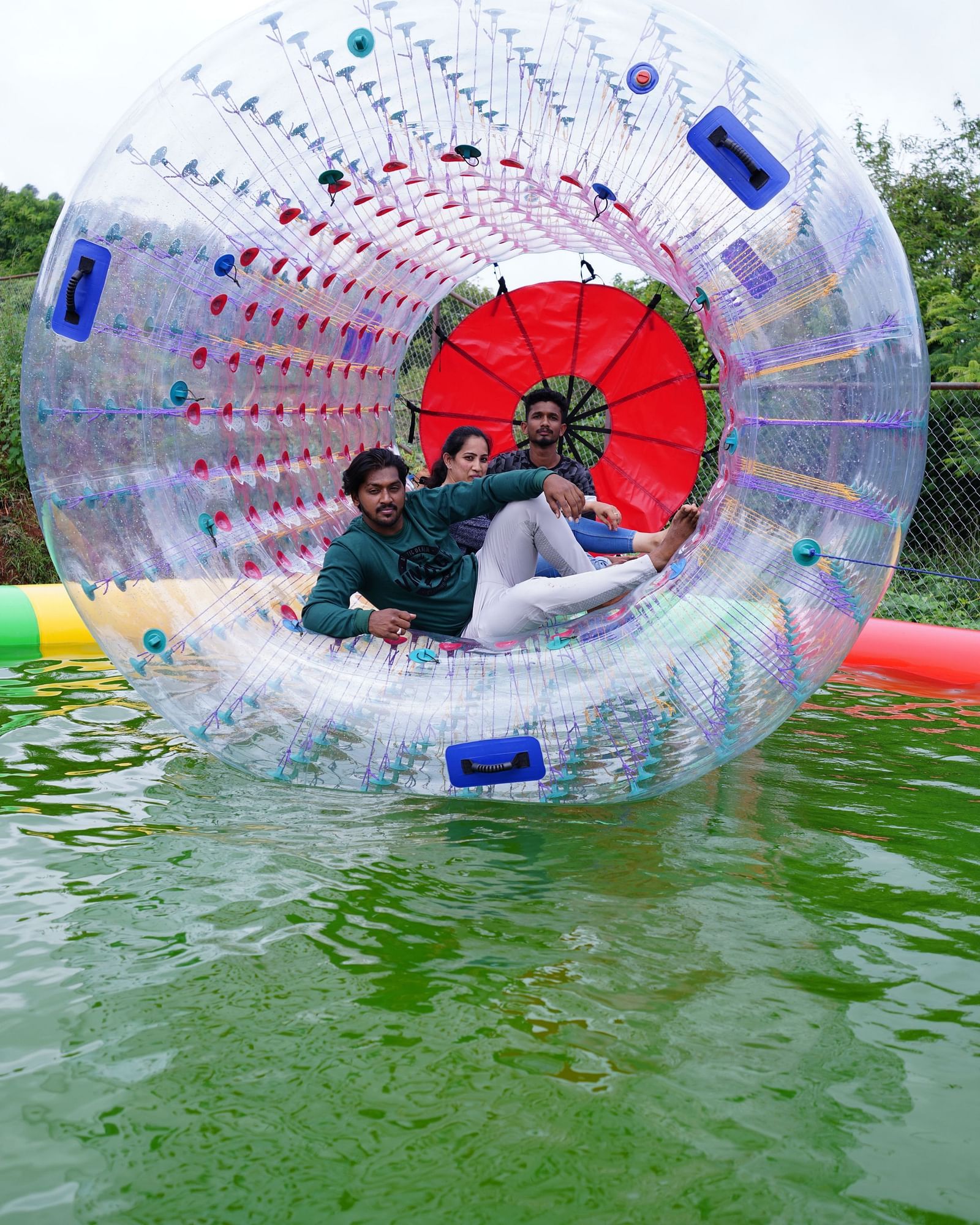 A group of three people enjoying water zorbing at Ravishing Retreat in a mini temporary pool