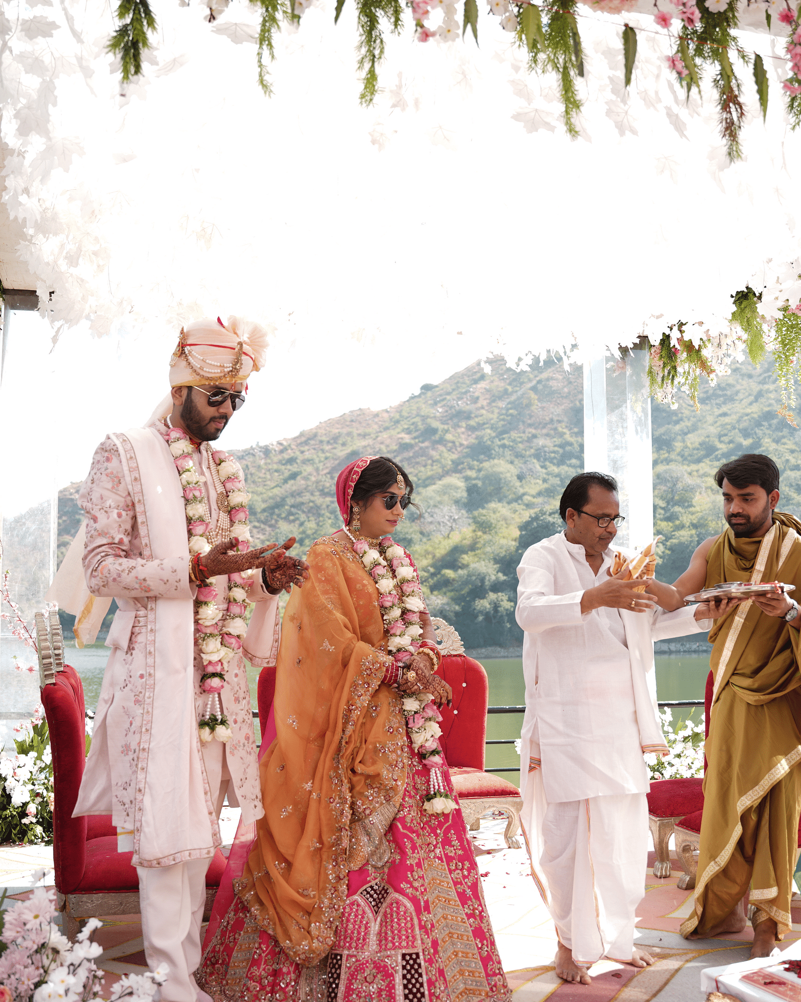Bride and groom in traditional attire, walking with family - Via Lakhela Resort & Spa