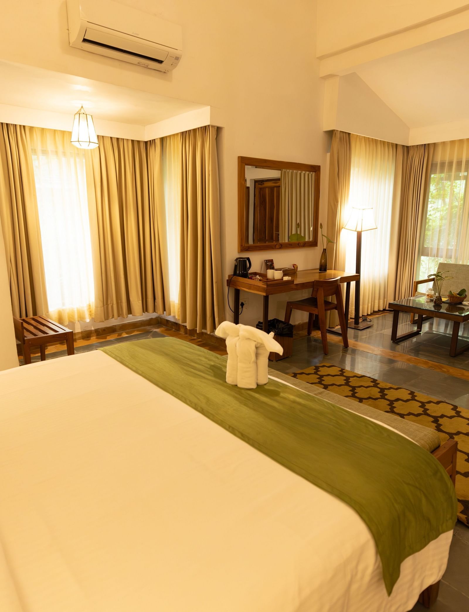Premium Room at Saraca Resort & Spa Corbett with a double bed, a sofa chair and work desk and chair set up