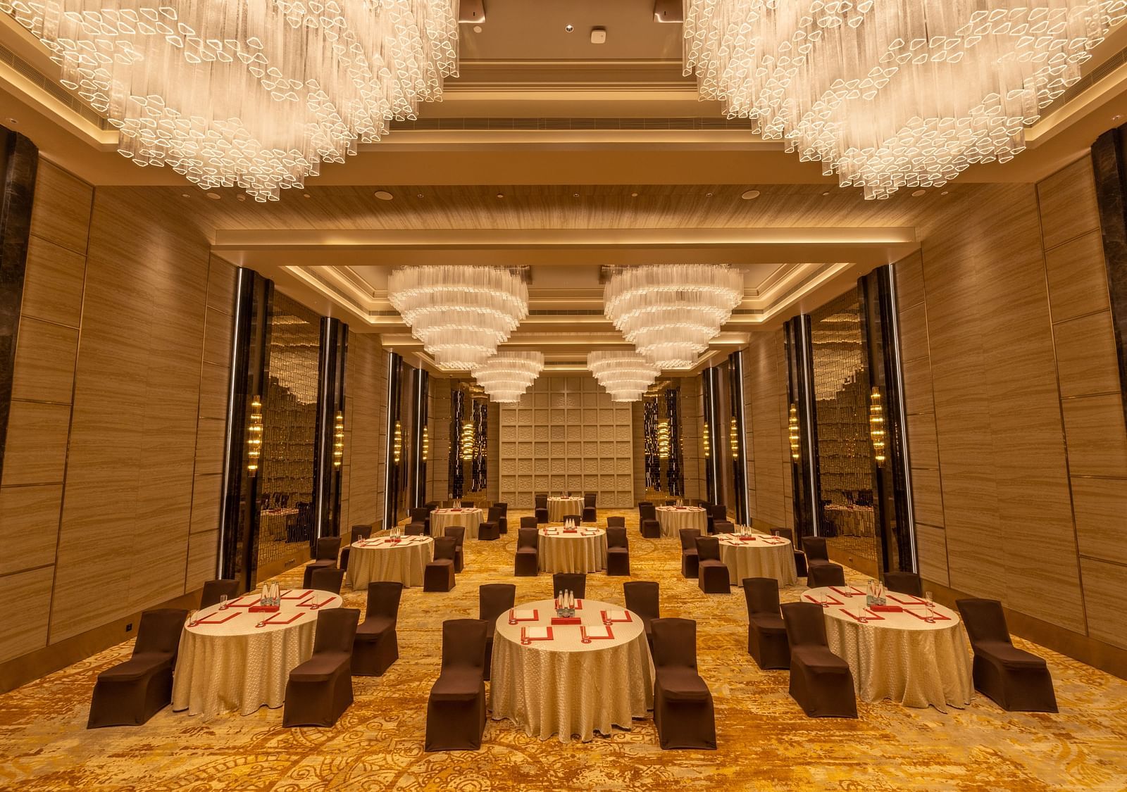 Grand banquet hall with elegant chandeliers and luxurious gold-accented decor - Grand Madurai by GRT Hotels