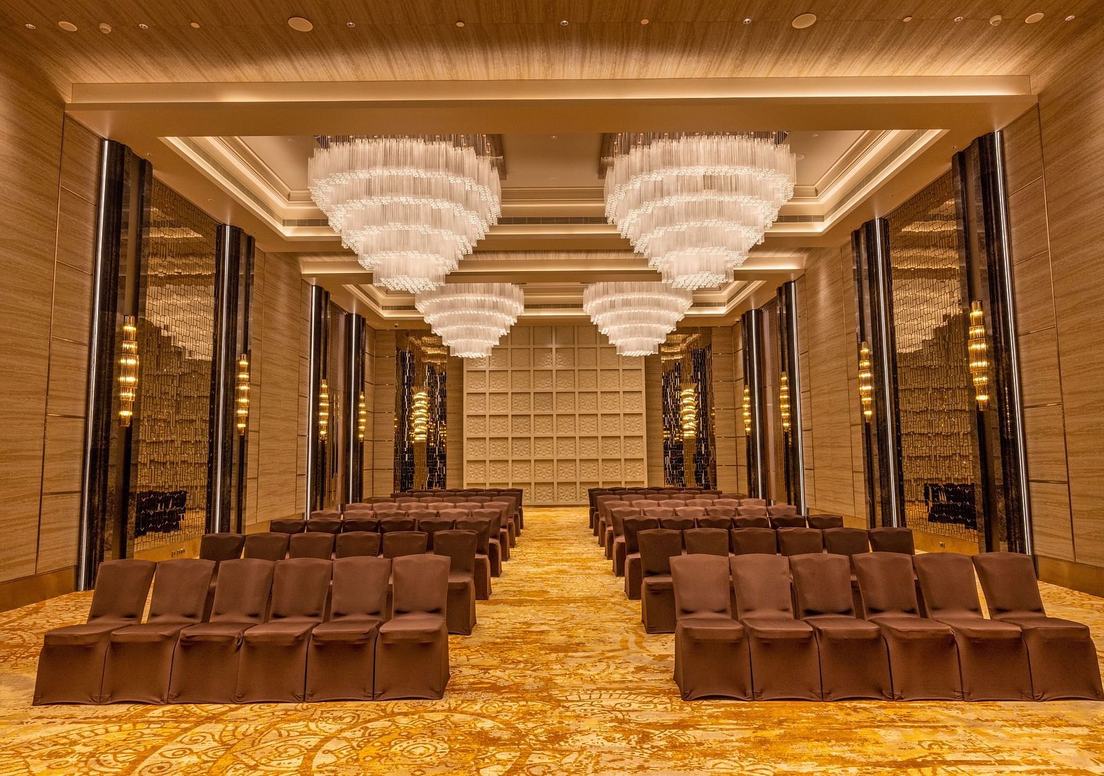 Banquet hall with theatre-style seating arrangement and majestic chandeliers - Grand Madurai by GRT Hotels