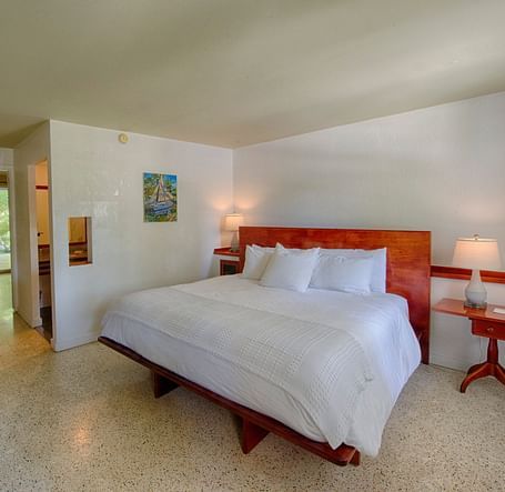 Casa Morada's bedroom with a king bed, wooden headboard, wall art, and a TV.