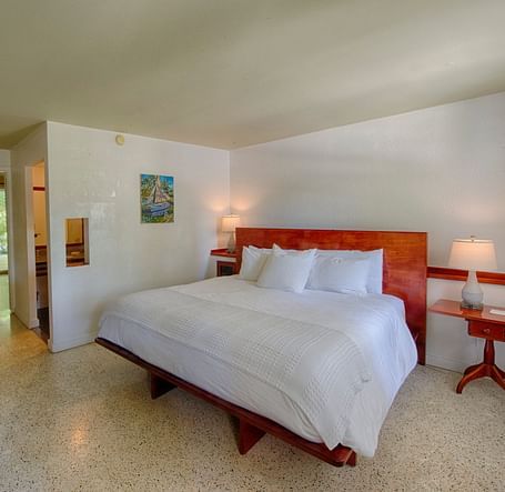 Casa Morada's bedroom with a king bed, wooden headboard, wall art, and a TV.