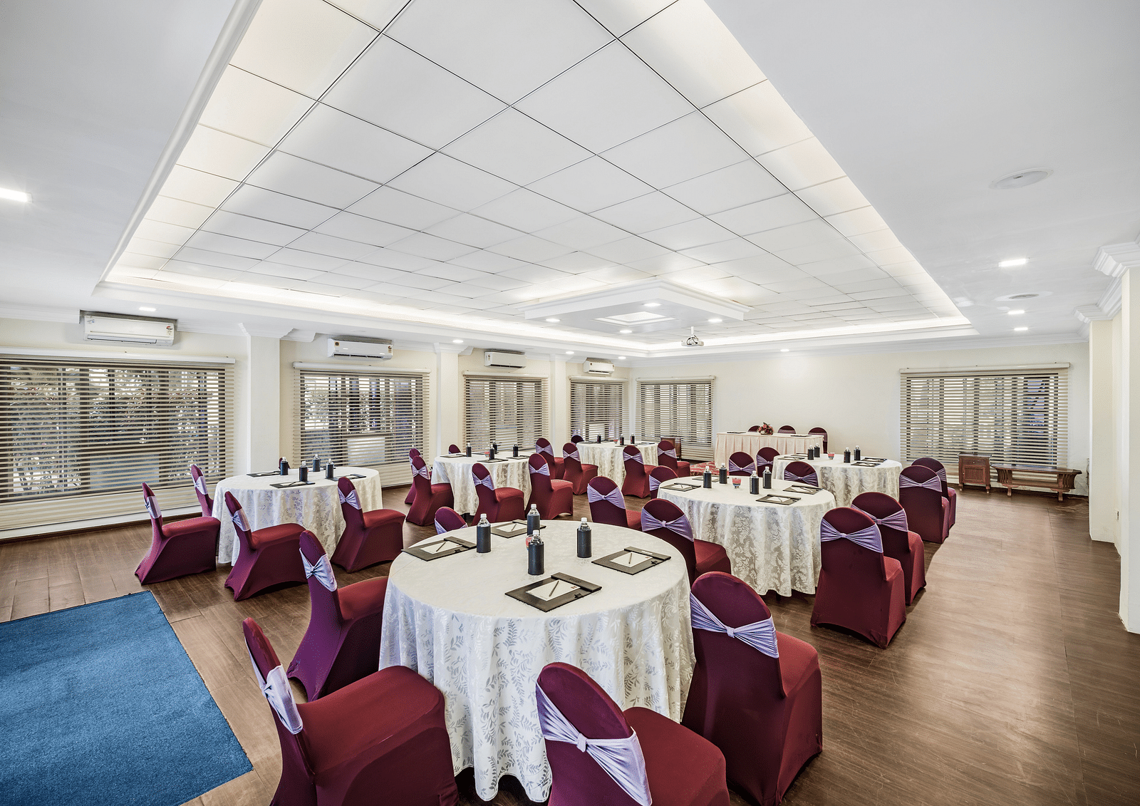 An image of a banquet hall with seating arrangement and bright lighting - GReaT Trails River View Resort Thanjavur By GRT Hotels