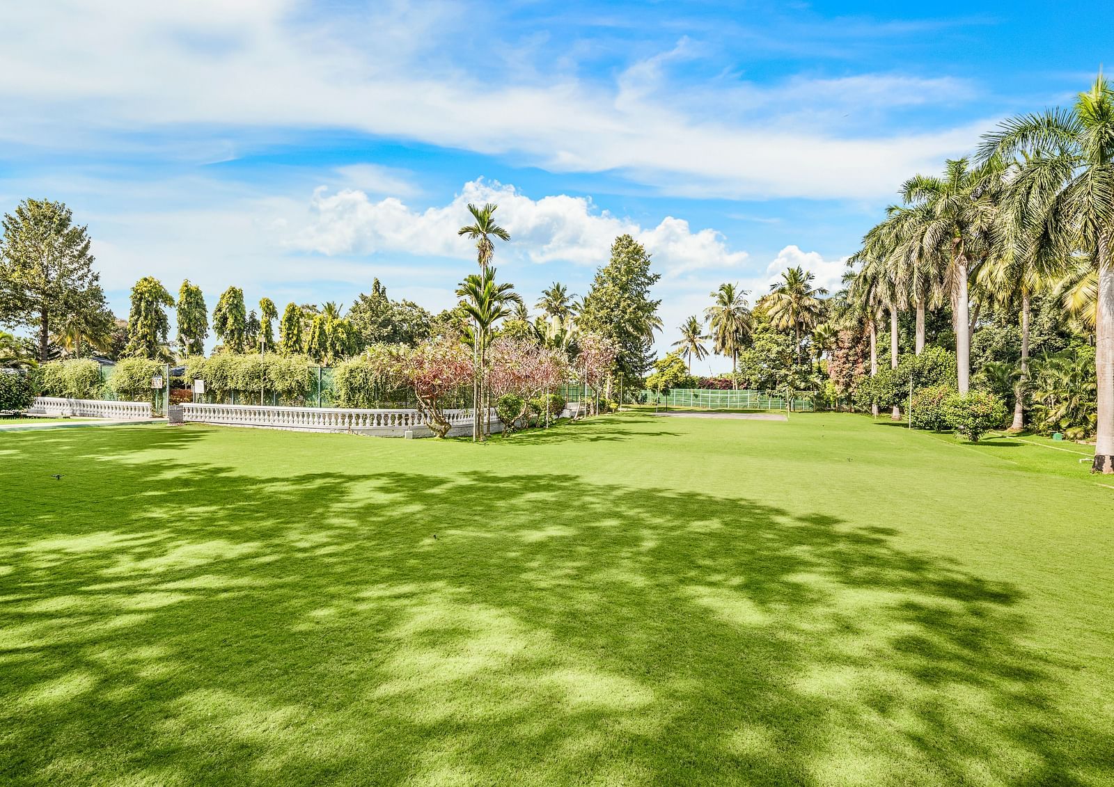 An image of the Vaanam event space which is an outdoor area with lush greenery and beautiful trees - GReaT Trails River View Resort Thanjavur By GRT Hotels