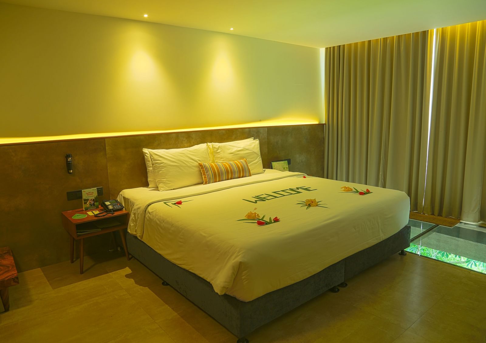 An image of the panorama view room with a king size bed, bed side table, and bright lighting - Great Trails Yercaud by GRT Hotels