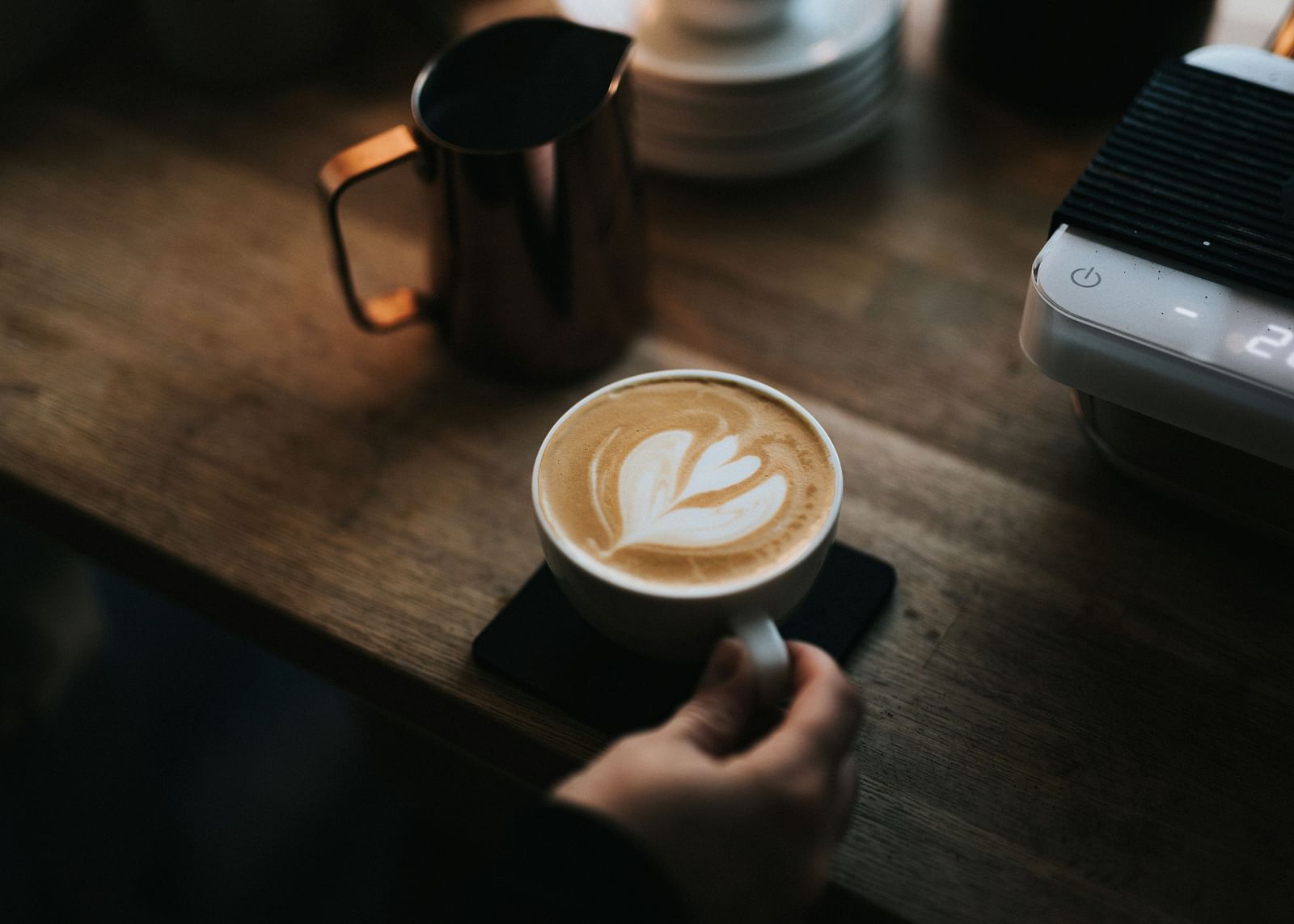 An image of a person holding a coffee cup placed on a table - Hotel 39, Jamaica
