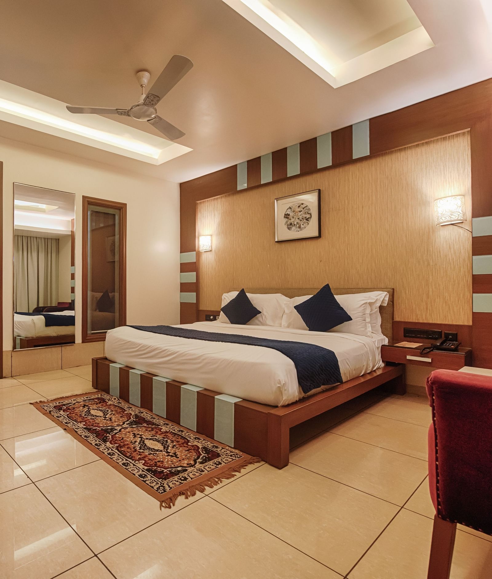 Villa at Crescent Resort, Sehore under warm lighting featuring a plush bed facing the wall-mounted TV and a mirror on one side of the bed
