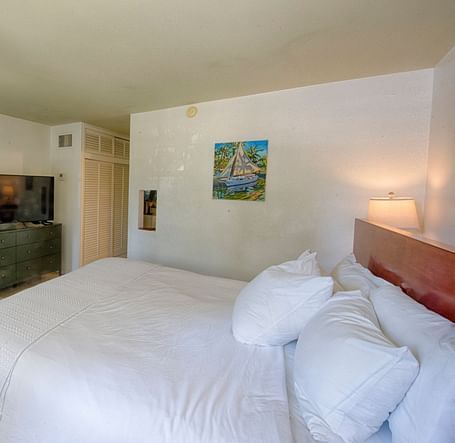White bed in a Casa Morada suite with a mirror, open floor space, and subtle lighting.