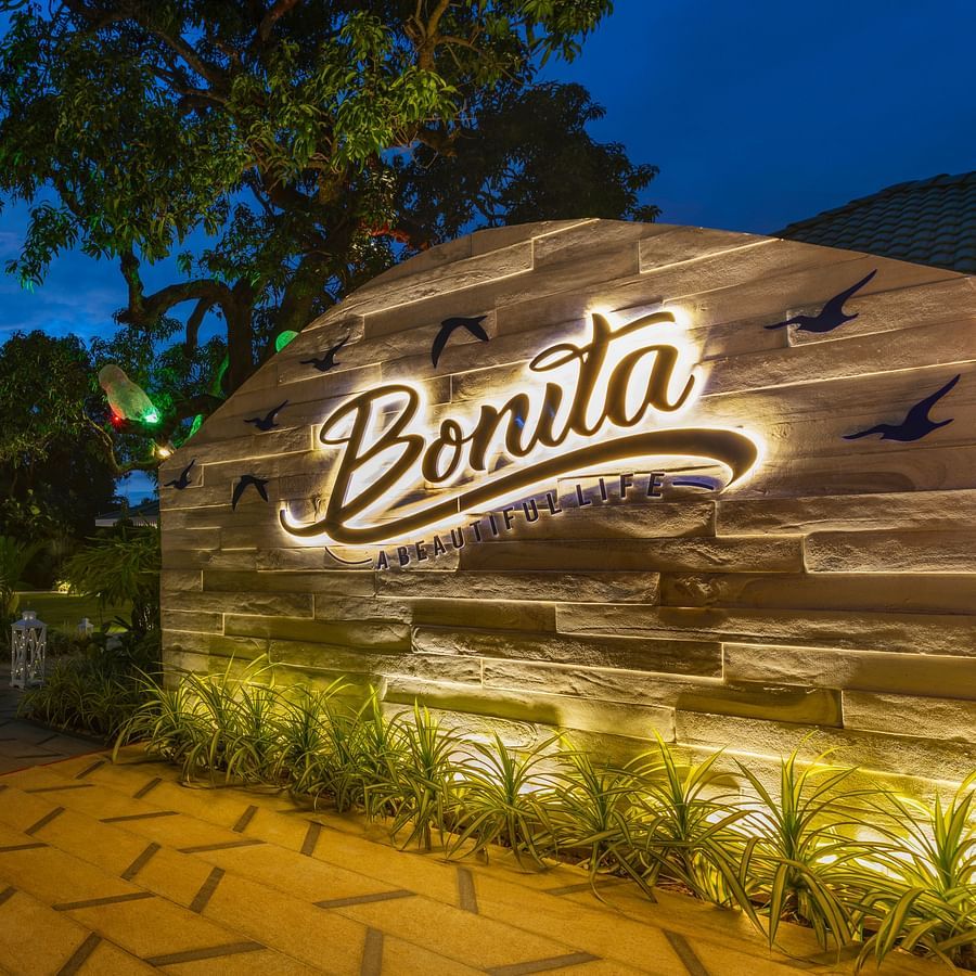 Exclusive Dining and BExterior view of the resort sign at night with lush surroundings at Heritage Village Resorts & Spa
