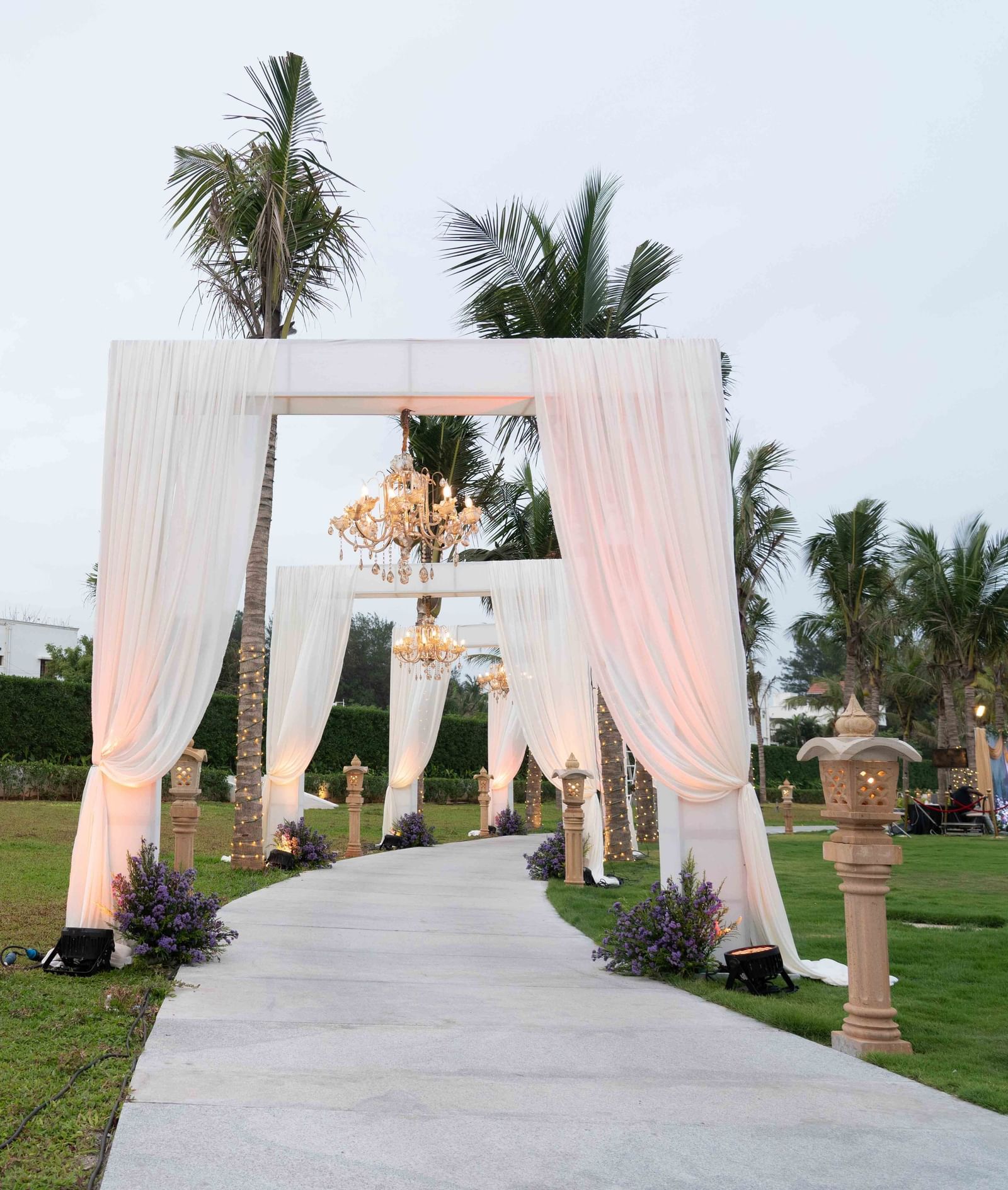 An pathway in the lawn with a lamp post and towering arches - Kaldan Samudhra Palace