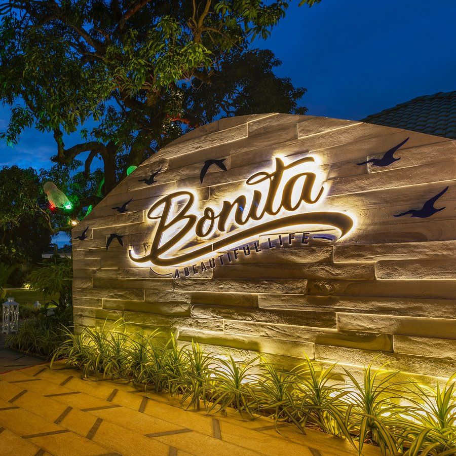 Exclusive Dining and BExterior view of the resort sign at night with lush surroundings at Heritage Village Resorts & Spa