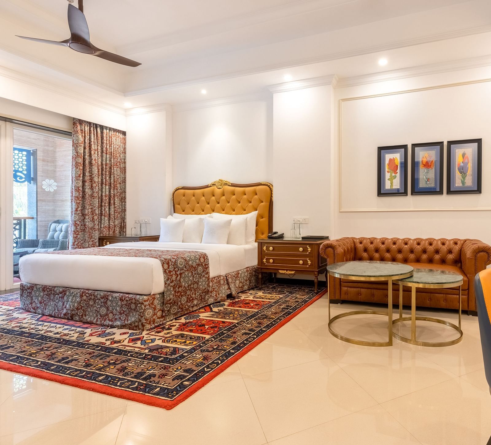 Double bedroom with a seating space, a workstation, ceiling fan, and large Glass windows at MAYFAIR Palm Beach Resort, Gopalpur-On-Sea