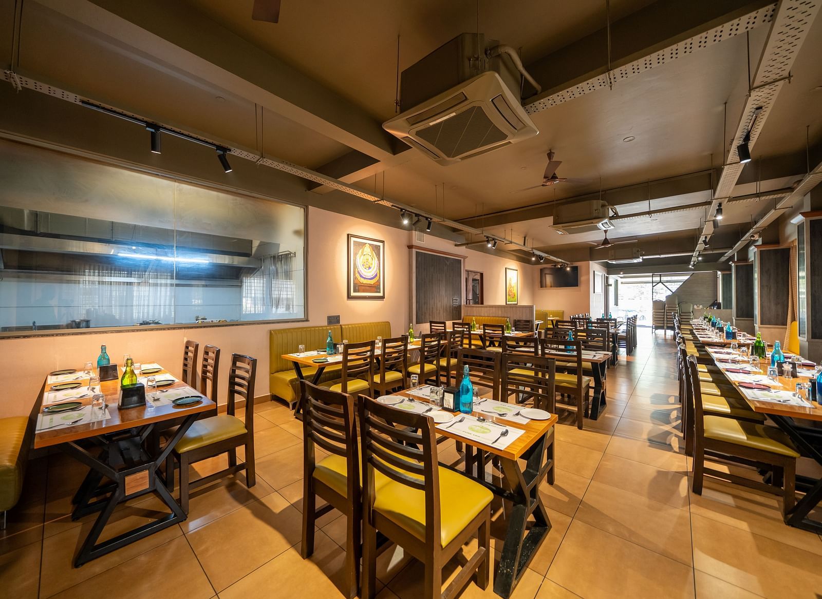 Image of a dining area with tables and chairs arranged around it at Hari Govindas, Siddappa Square.