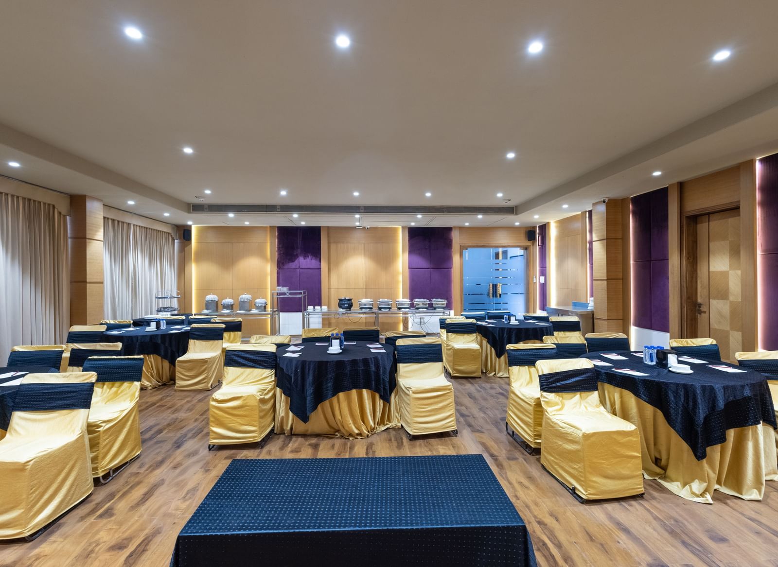 Banquet hall, Iris, with tables in cluster seating arrangment, wooden flooring, seen at Pravasa Stay Vijay Nagar, Indore.
