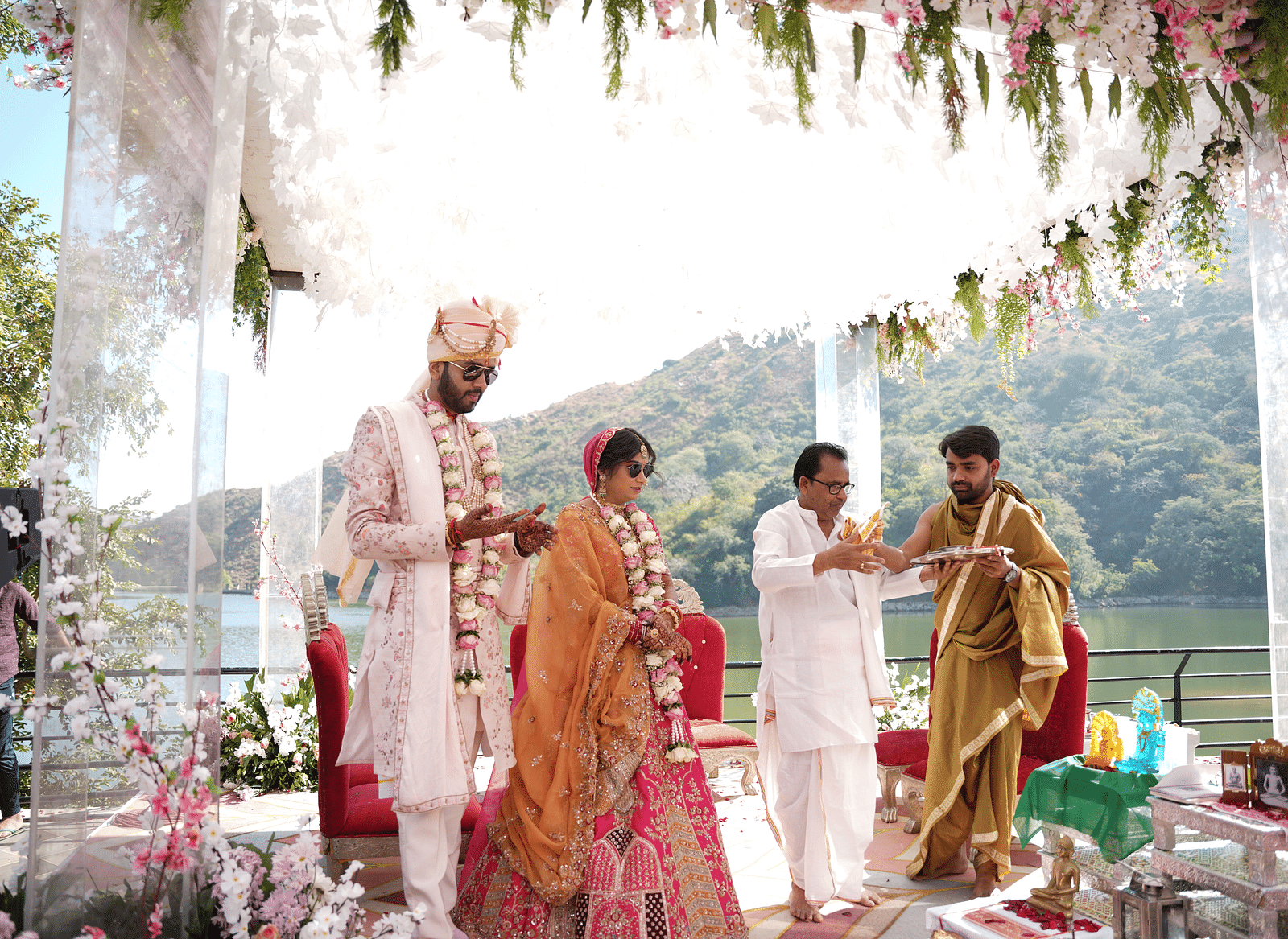 Bride and groom in traditional attire, walking with family - Via Lakhela Resort & Spa