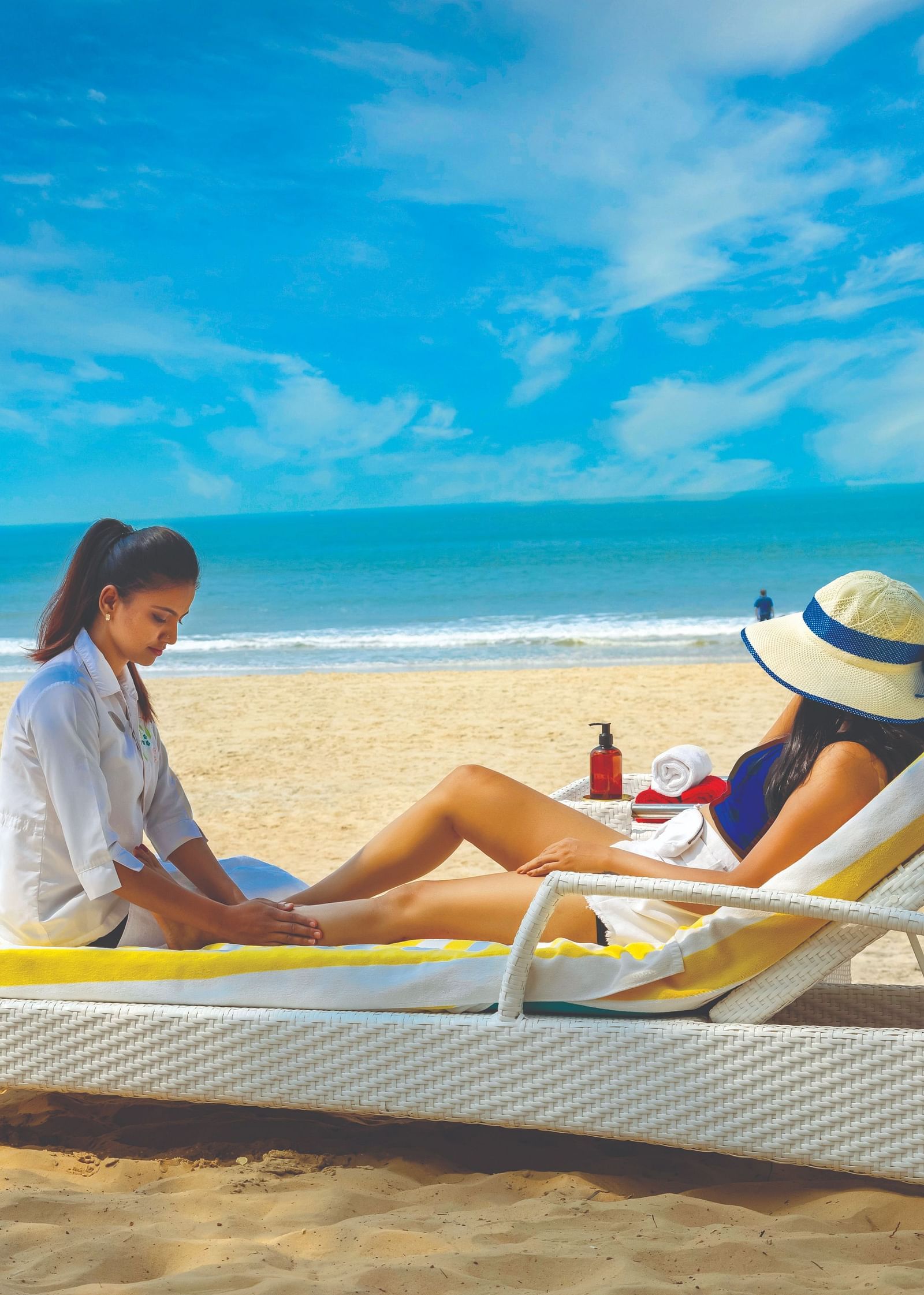  two women sitting on the lounger on the beach - Caravela Beach Resort Goa