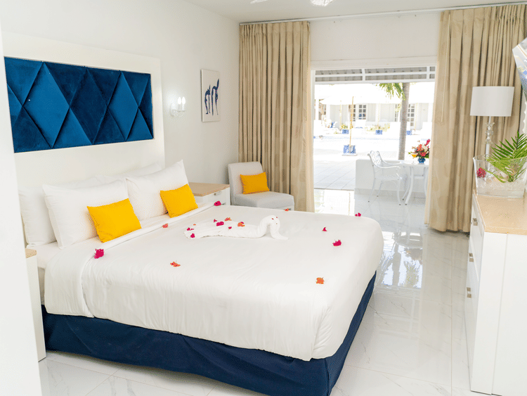 Spacious bedroom at The Soco House with a king bed, blue diamond-patterned headboard, and rose petals.