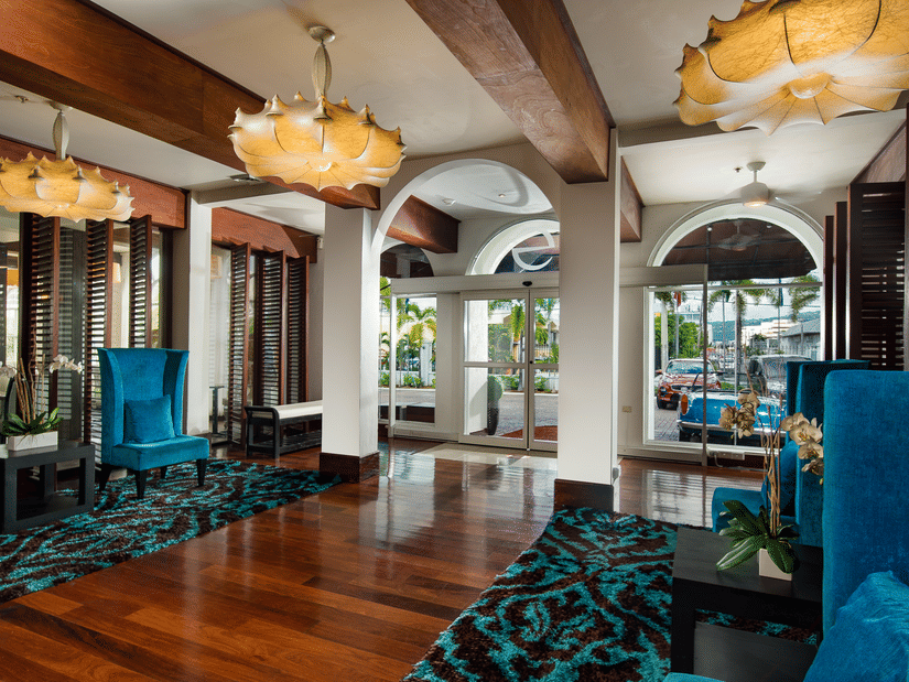 A hotel lobby shimmering with orange chandeliers and blue upholstered couches - S Hotel Kingston, Jamaica