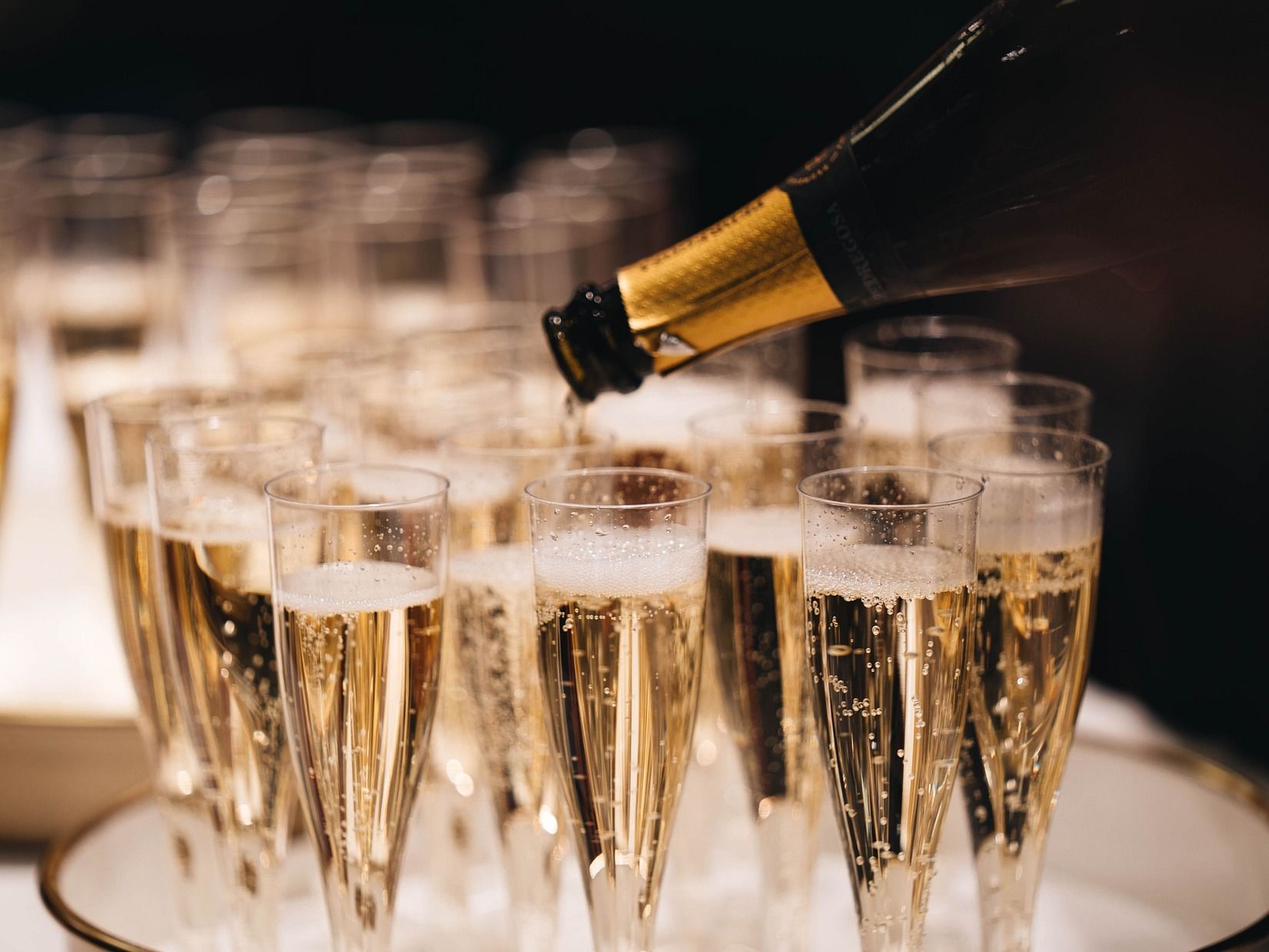 Champagne served in glasses from a champagne bottle placed on a white tray at Villa In Palms by V Escapes 