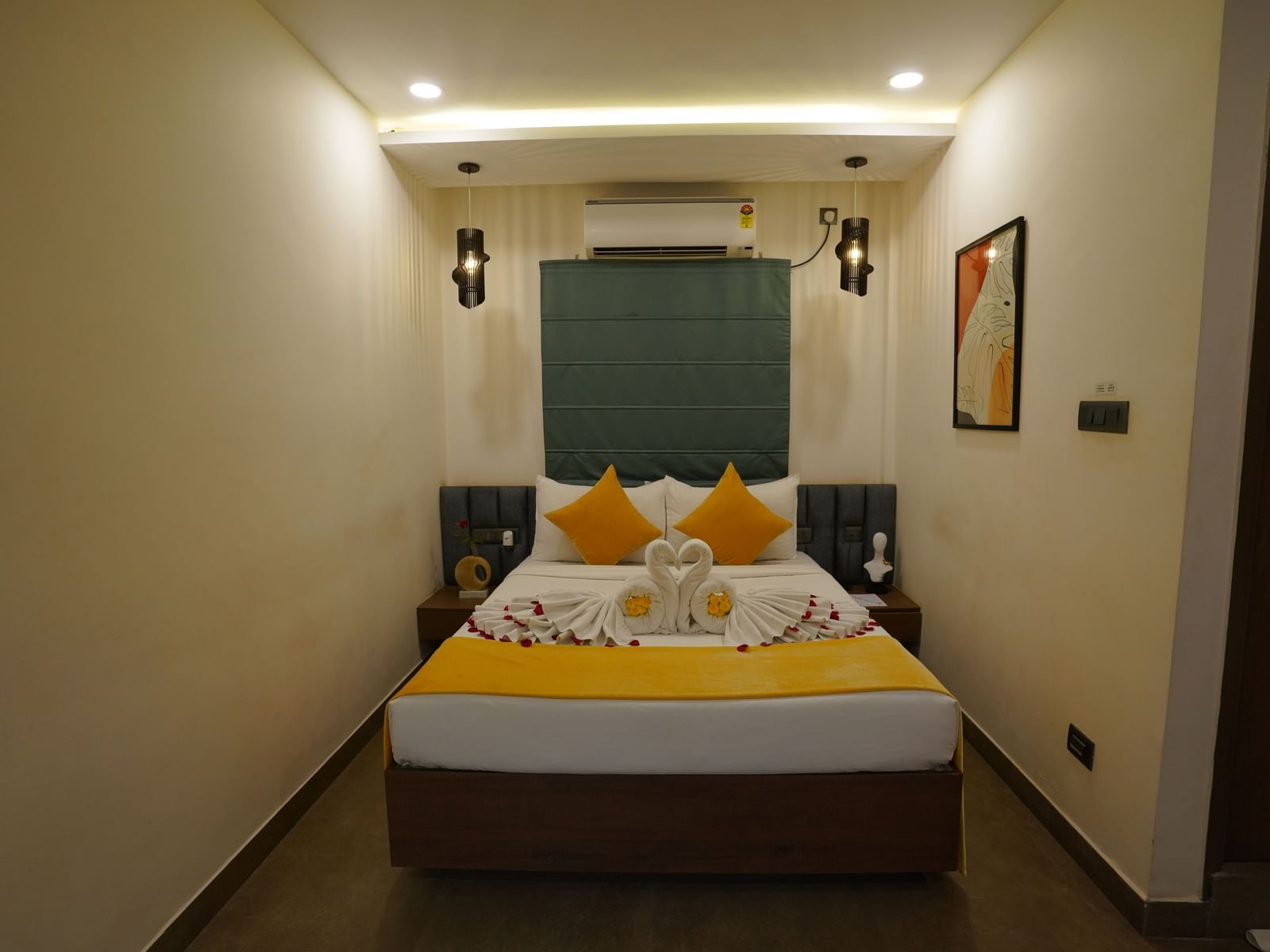 A well-lit bedroom featuring a double bed with a portrait on the wall at Hotel Kyzen Smartstays – Smart, Reliable, Kyzen