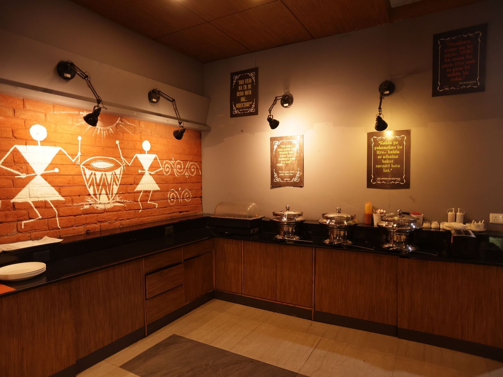 A dimly lit hotel buffet area with a marble counter and decorative items at Max Hotel Prayagraj.