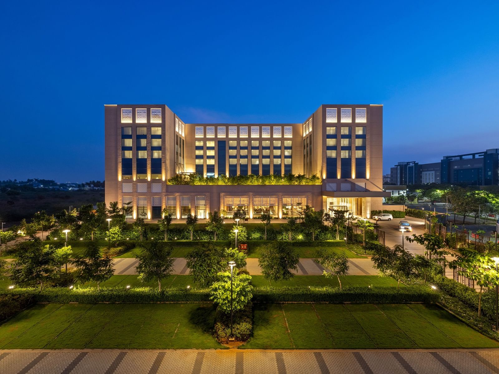 A striking twilight aerial perspective of the hotel, surrounded by manicured lawns - Grand Madurai by GRT Hotels