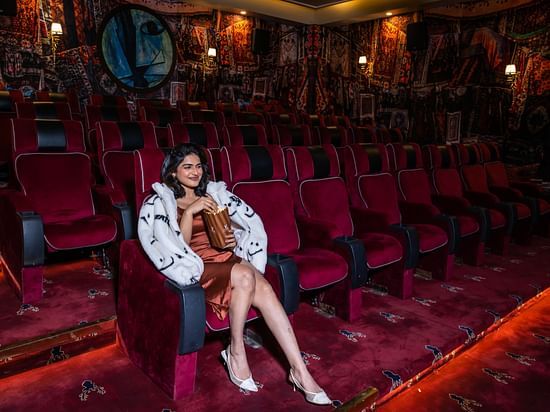 A person enjoying a movie in our private theatre with popcorn in hand  - The Manor Luxury Hotel, Shimla