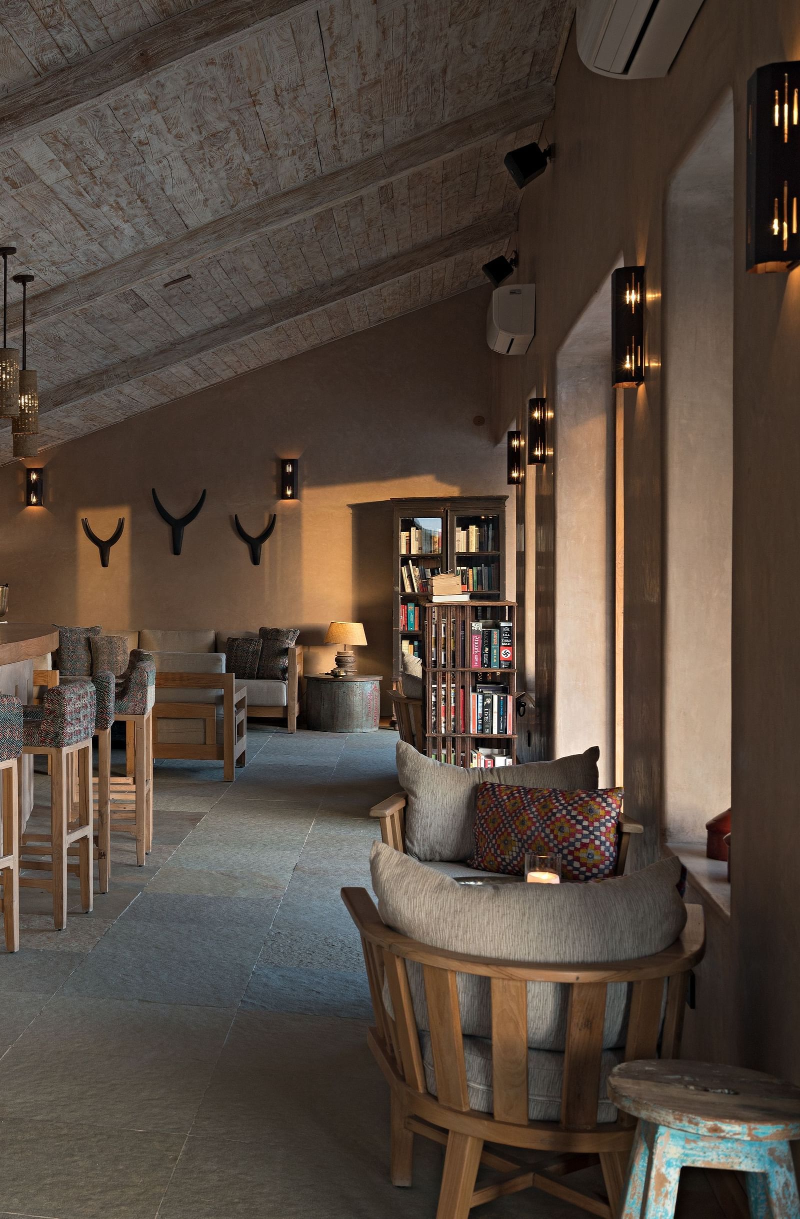 An image of a restaurant area with the seating arrangement and the counter which is decorated with traditional wooden pieces - MANVAR Resort and Desert Camp 