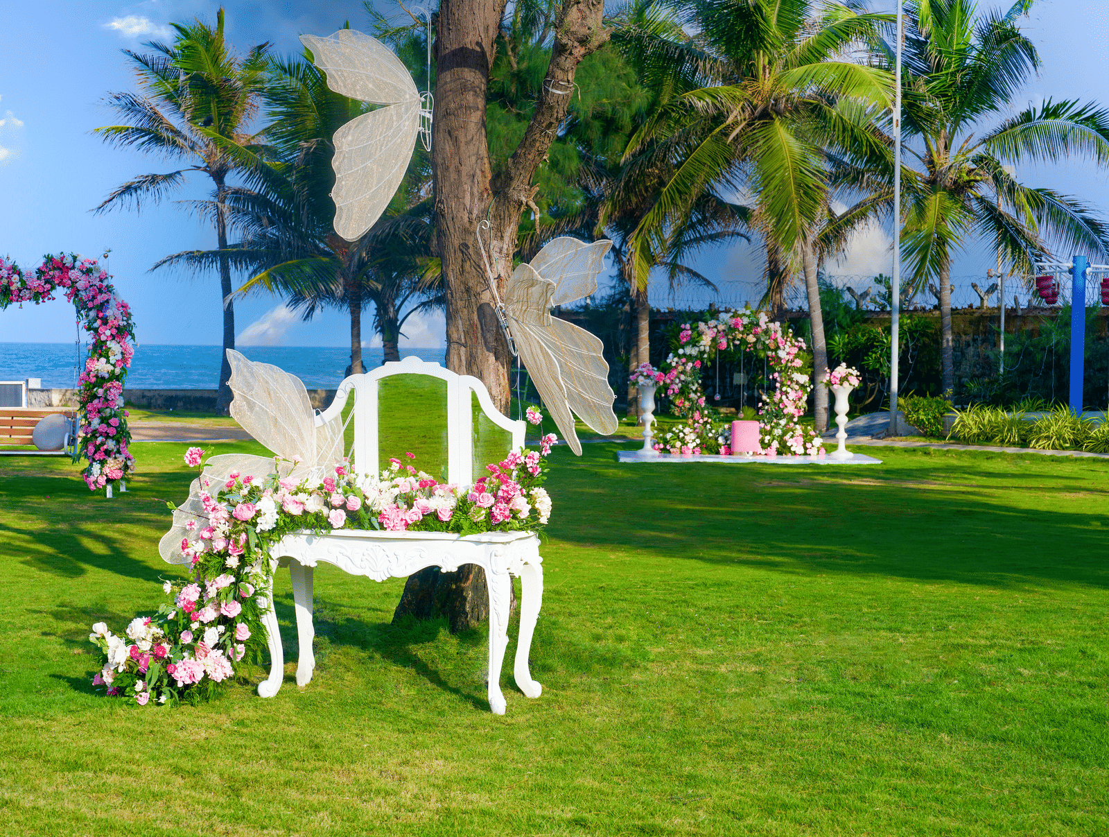 White garden chair decorated with butterflies and cascading flowers on the lawn - Grande Bay Resort & Spa, Mamallapuram